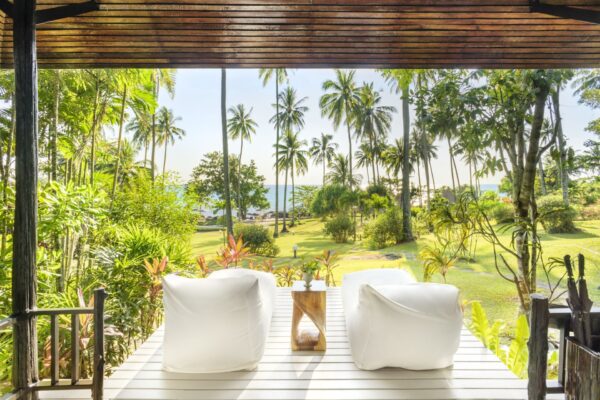Hvide loungestole på trædæk i SHANTAA, Koh Kood med udsigt over frodig tropisk have