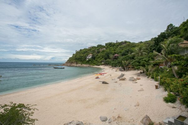 Fotografi af en travl sandet strand fyldt med mennesker, der nyder deres tid på Sai Daeng Resort.