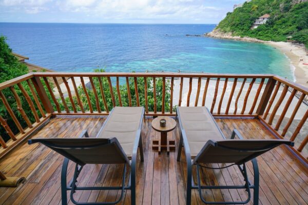 Søgning efter et par lounge stole på en træterrasse med udsigt over havet på Sai Daeng Resort