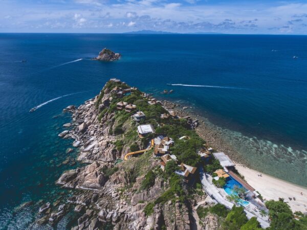 Luft Sai Daeng Resort, ø-tilflugtssted i Thailand med skurke ved stranden, krystalklart vand, frodigt grønt og nærliggende koralrev til