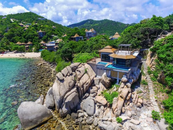 Overhead udsigt over Sai Daeng Resort beliggende på en stenet, isoleret ø med frodig vegetation og klart omgivende vand