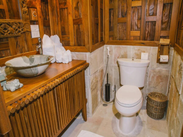 Træbeklædt badeværelse med toilet på Santhiya Koh Phangan Resort & Spa