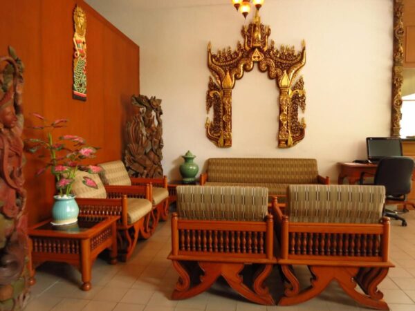 Hotel Sirin i Hua Hin tilbyder hyggeligt værelse med elegante træmøbler og smukt designet vægudsmykning