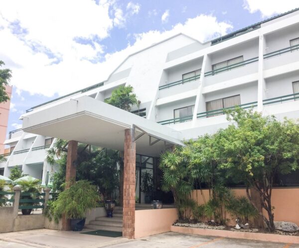 Indgangen til Sirin Hotel Hua Hin omgivet af træer og planter