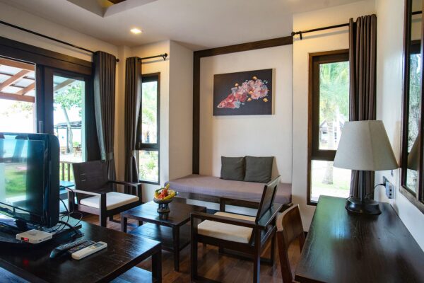 Interiør af stue på Southern Lanta Resort med fladskærms-tv og komfortabel stole.