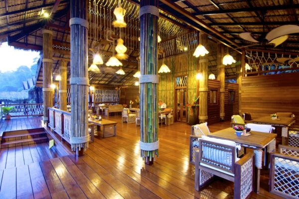 Tropisk resort restaurant ved River Kwai med trægulv og bambusstolper
