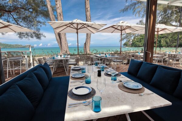 Twinpalms Phuket udendørs spiseområde med blå sofaer og paraplyer