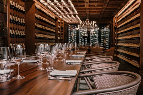 Billedbeskrivelse: Et elegant indrettet vinrum ved Twinpalms Phuket resort, komplet med en lang bord indstilling.