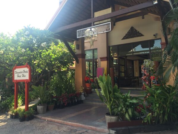 Entréen til Wannara Hotel Hua Hin dekoreret med mange potteplanter.