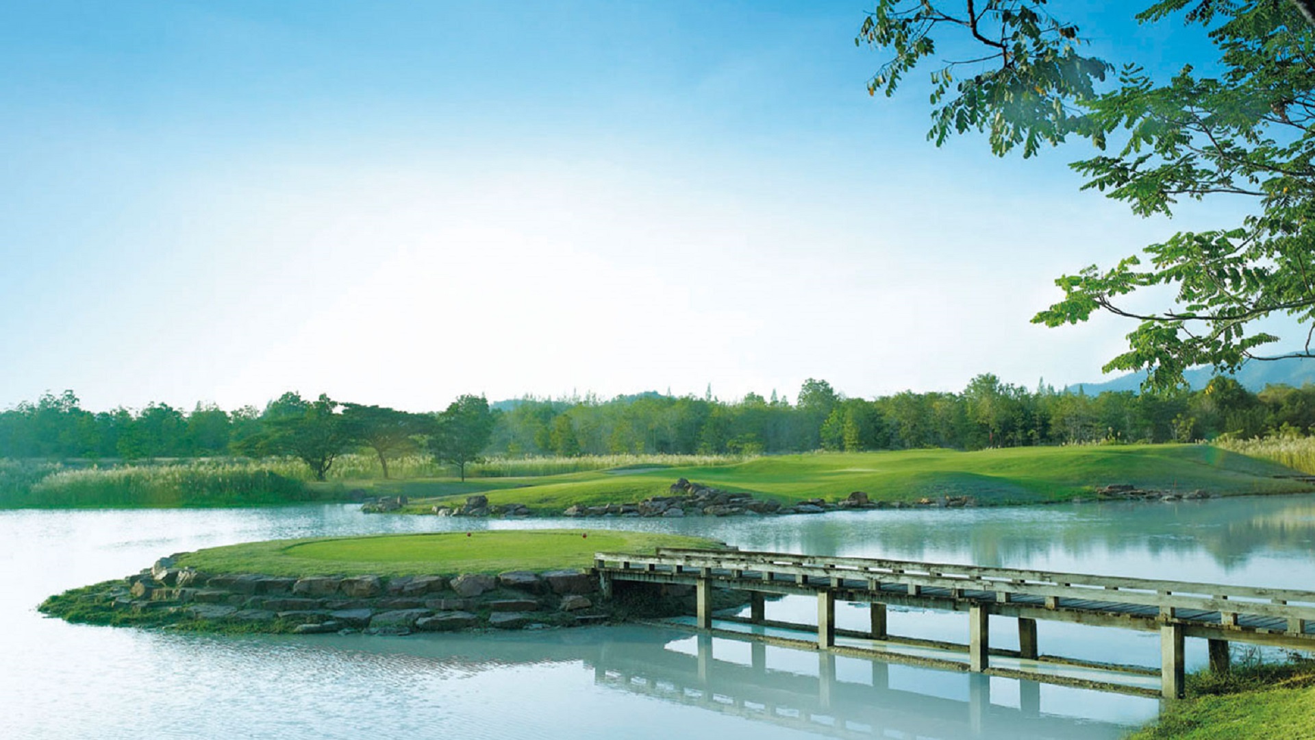 Nyd en rolig golfoplevelse på Imperial Lake View Resort og Golf Club i Hua Hin med billedskøn bro over en fredelig sø.