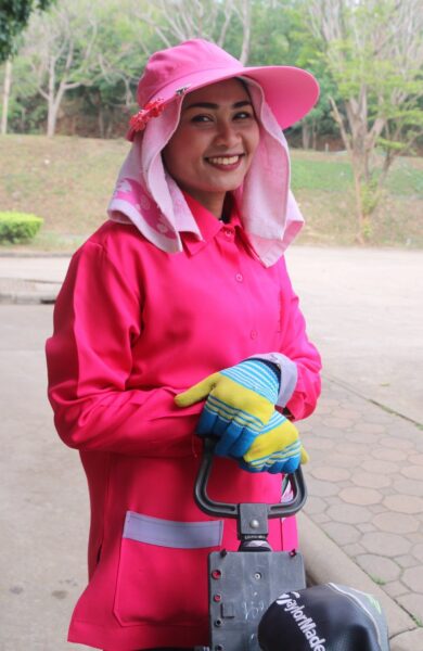 Kvinde i rosa jakke holder græsslåmaskine på Kaeng Krachan Golf & Country Club