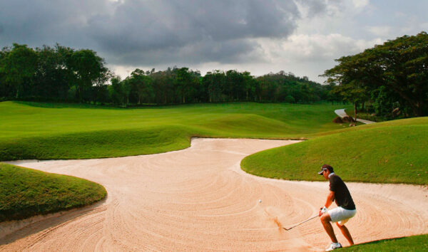 Man slår golfbold i sandbunker på Laem Chabang International Country Club