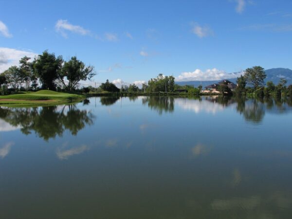 Golfkursus i Chiang Mai med sø og bjerge i baggrunden