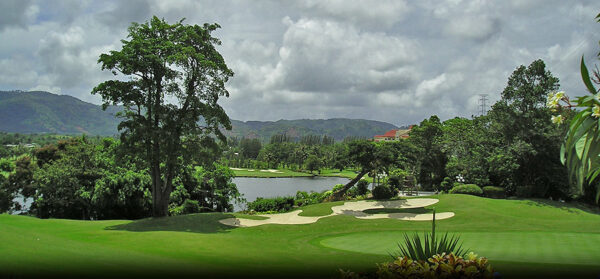 Phuket Country Club golfbane, omgivet af frodige træer og majestætiske bjerge