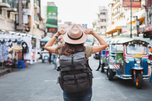 Kvinde med rygsæk går ned af gade i Bangkok, Thailand under Rundrejse