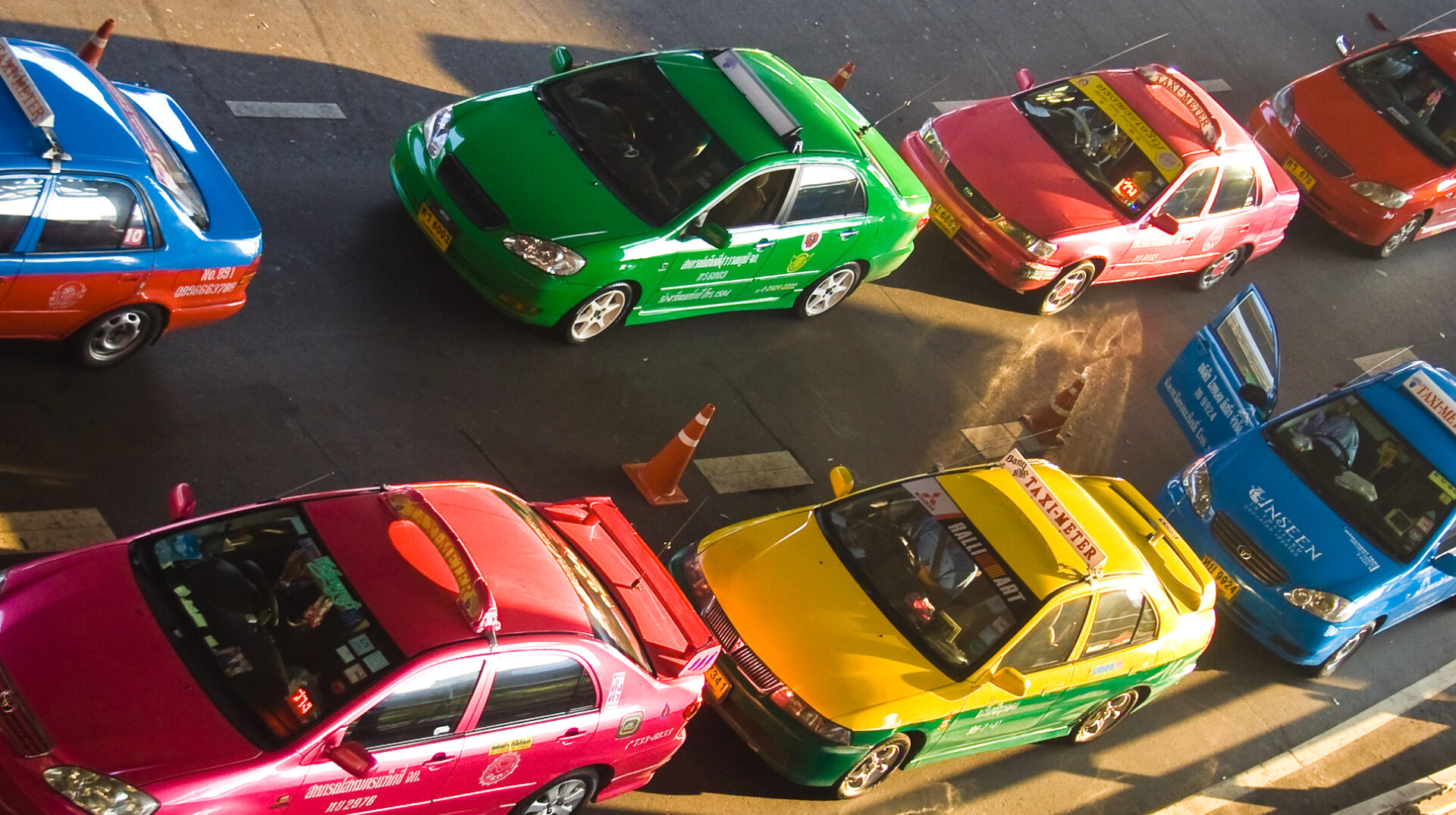 Gruppe af farverige taxier parkeret på en gade i Thailand