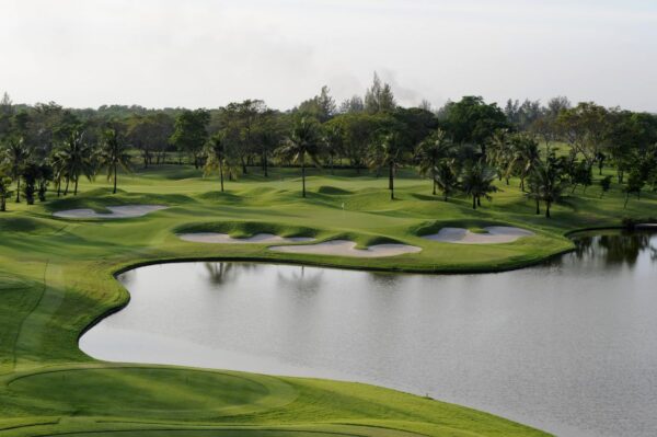Bangkok golfbane ved Thai Country Club med malerisk sø og omgivet af frodige træer, som tilbyder en rolig oase for golfspillere.