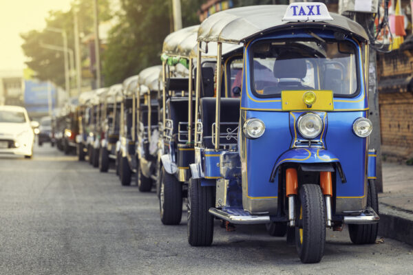 Farverige Tuk Tuks linet op i rækken på Bangkok gade