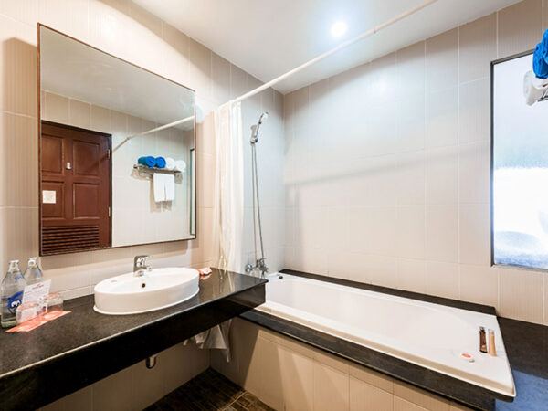 Kata Sea Breeze Resort Phuket badeværelse med vask, badekar og spejl