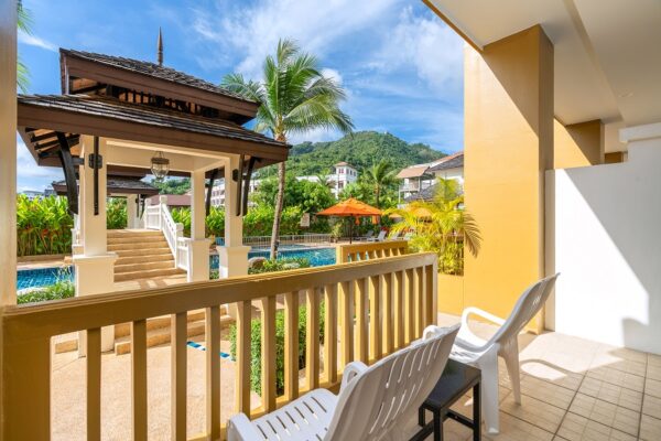 Oplev en idyllisk udsigt fra balkonen på Kata Sea Breeze Resort. Her kan du nyde synet af et smukt swimmingpoolområde omgivet af frodige