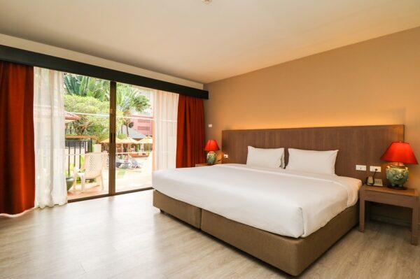 Hotelværelse med stor seng og skydedøre i glas på Kata Sea Breeze Resort, Phuket