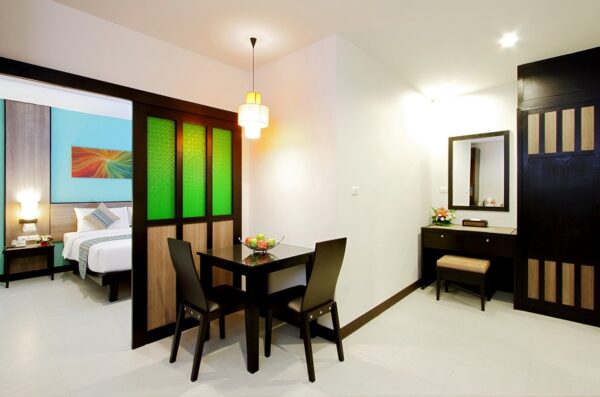 Komfortabelt værelse på Kata Sea Breeze Resort i Phuket med seng, bord og stole