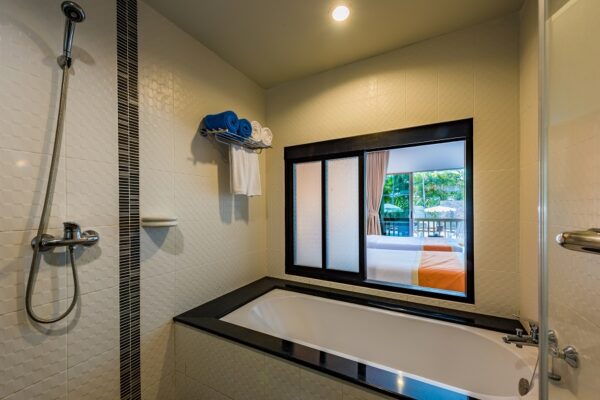 Kata Sea Breeze Resort Phuk har luksuriøst badeværelse med badekar, brusebad og vindue.
