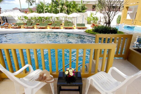 Kata Sea Breeze Resort i Phuket: Poolområde med behagelig stole og parasoller til solbadning og afslapning.