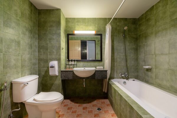 Grønt badeværelse med toilet og håndvask på Sea Breeze Resort