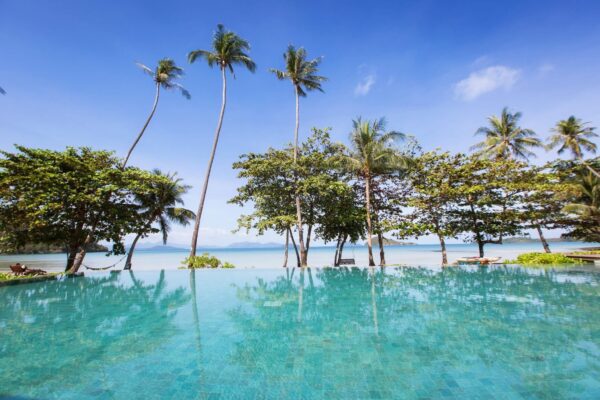Swimmingpool i tropiske omgivelser på Mira Montra Koh Mak resort med palmer og strandudsigt