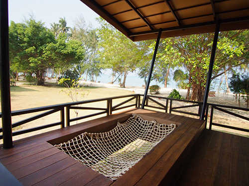 Nyd afslapning på en træterrasse med hængekøje hos Koh Mak Beach Resort, Seavana. Perfekt til feriegæster der elsker fred og ro ved kysten.